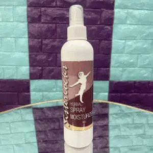 A white spray bottle labeled "Spray Moisturizer" on a patterned surface.